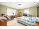 Comfortable bedroom featuring two windows, a writing desk, and a quilt-covered bed. Neutral carpet at 3497 Highway 5, Douglasville, GA 30135