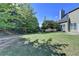 Spacious green backyard with trees, shrubs, and partial view of the home at 645 Earlham Dr, Suwanee, GA 30024