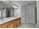 Bathroom with double sink vanity, tile floor, and large mirror reflecting the shower at 645 Earlham Dr, Suwanee, GA 30024
