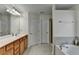Bathroom featuring a vanity, soaking tub, tile floors, and a separate shower stall at 645 Earlham Dr, Suwanee, GA 30024