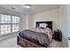 Comfortable bedroom features a dark wood bed frame, carpet, and bright window at 645 Earlham Dr, Suwanee, GA 30024