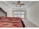 This bedroom features a tray ceiling, ceiling fan, and bright windows at 645 Earlham Dr, Suwanee, GA 30024