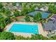 Large community pool surrounded by green trees, lounge chairs, and a playground at 645 Earlham Dr, Suwanee, GA 30024