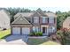 Charming two-story brick home featuring a two-car garage and well-manicured front yard at 645 Earlham Dr, Suwanee, GA 30024