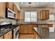 Updated kitchen with stainless steel gas range, granite countertops, and a central island at 645 Earlham Dr, Suwanee, GA 30024