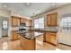 Well-lit kitchen with a center island, tile backsplash, and stainless steel appliances at 645 Earlham Dr, Suwanee, GA 30024