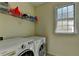 Laundry room with side-by-side washer and dryer and a window for natural light at 645 Earlham Dr, Suwanee, GA 30024