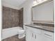 Bathroom featuring a shower-tub combo with tiled walls, vanity with granite countertop, and a large mirror at 2520 Wood Fern Ln, Cumming, GA 30041