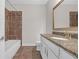 Bathroom showcases granite countertops, a framed mirror and a tiled shower-tub combination at 2520 Wood Fern Ln, Cumming, GA 30041