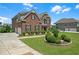 Well-maintained brick home with lush landscaping, showcasing a driveway and a detached garage at 2520 Wood Fern Ln, Cumming, GA 30041