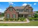 Stately brick home boasts manicured landscaping, a stone accent wall, and a welcoming front porch at 2520 Wood Fern Ln, Cumming, GA 30041