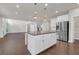 Spacious kitchen featuring a central island, stainless steel appliances, and seamlessly connected to the open-concept living area at 2520 Wood Fern Ln, Cumming, GA 30041