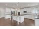 Modern kitchen with white cabinets, granite countertops, stainless steel appliances, and a center island with pendant lighting at 2520 Wood Fern Ln, Cumming, GA 30041