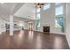 Bright, open-concept with hardwood, a fireplace, tall windows, and white kitchen in background at 2520 Wood Fern Ln, Cumming, GA 30041