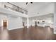 Open-concept living room featuring hardwood floors, soaring ceilings, and a modern kitchen with stainless steel appliances at 2520 Wood Fern Ln, Cumming, GA 30041