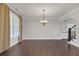 Bright room with dark hardwood floors, an elegant chandelier, and doorway to the kitchen at 2520 Wood Fern Ln, Cumming, GA 30041