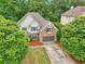 Charming two-story home with brick and shingle accents, surrounded by mature trees and lush landscaping at 3874 Lost Oak Dr, Buford, GA 30519