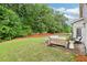 A well-manicured backyard featuring lush greenery, a cozy patio, and comfortable outdoor furniture at 3874 Lost Oak Dr, Buford, GA 30519