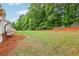 A spacious backyard with ample green space, mature trees, and a wood fence is perfect for outdoor activities at 3874 Lost Oak Dr, Buford, GA 30519