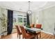 Elegant dining room with tray ceiling, hardwood floors, bright windows, and stylish lighting at 3874 Lost Oak Dr, Buford, GA 30519