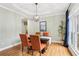 Formal dining room featuring a tray ceiling, hardwood floors, and a large window for natural light at 3874 Lost Oak Dr, Buford, GA 30519