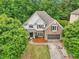Charming two-story home with brick and shingle accents, surrounded by mature trees and lush landscaping at 3874 Lost Oak Dr, Buford, GA 30519