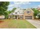 Beautiful two-story home with a brick facade, lush lawn, mature trees, and a two car garage at 3874 Lost Oak Dr, Buford, GA 30519