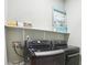 Laundry room with front load washer and dryer, white shelf, and modern artwork at 3874 Lost Oak Dr, Buford, GA 30519