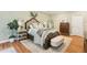 Nicely decorated main bedroom offers a neutral color palette, wood floors, and decorative textiles at 3874 Lost Oak Dr, Buford, GA 30519