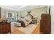 Spacious main bedroom with tray ceilings, warm wood floors, and cozy sitting area at 3874 Lost Oak Dr, Buford, GA 30519