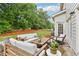 Cozy outdoor patio with comfortable seating, a grill, and a serene view of the lush, green backyard at 3874 Lost Oak Dr, Buford, GA 30519