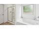 The bathroom features a glass door shower, a soaking tub, and a window at 5320 Flat Rock Pt, Lithonia, GA 30038