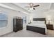 Well-lit main bedroom with a ceiling fan, tray ceiling, and a dresser at 5320 Flat Rock Pt, Lithonia, GA 30038