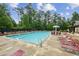 Community pool surrounded by lounge chairs and mature trees, perfect for relaxation and recreation at 5320 Flat Rock Pt, Lithonia, GA 30038