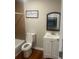 Bathroom featuring a toilet, vanity, mirror, and shower with tile surround at 10 Rockmart Nw Dr, Atlanta, GA 30314
