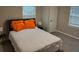 Comfortable bedroom featuring plush carpet, a bed adorned with orange accents, and abundant natural light at 10 Rockmart Nw Dr, Atlanta, GA 30314