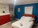 Comfortable bedroom with red accent wall, colorful decor, and queen bed with soft white linens at 10 Rockmart Nw Dr, Atlanta, GA 30314