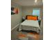 Cozy bedroom with neutral walls, plush carpet, and a bed adorned with orange accents and a modern abstract art piece at 10 Rockmart Nw Dr, Atlanta, GA 30314