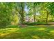 Expansive backyard with lush greenery and mature trees provides a serene, private outdoor space at 1150 Kennesaw Due West Nw Rd, Kennesaw, GA 30152