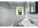 Clean bathroom with tiled walls, a window, and classic fixtures at 1150 Kennesaw Due West Nw Rd, Kennesaw, GA 30152