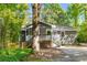 A cozy home nestled amidst trees features a welcoming porch, blending seamlessly with nature's charm at 1150 Kennesaw Due West Nw Rd, Kennesaw, GA 30152