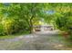 Quaint grey home with a charming front porch and spacious gravel driveway surrounded by mature trees at 1150 Kennesaw Due West Nw Rd, Kennesaw, GA 30152