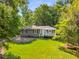A quaint home featuring a lush lawn, mature trees, and a covered porch, perfect for relaxing outdoors at 1150 Kennesaw Due West Nw Rd, Kennesaw, GA 30152