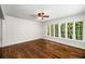 Bright living room with large windows overlooking lush greenery and refinished floors at 1150 Kennesaw Due West Nw Rd, Kennesaw, GA 30152