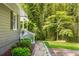The home has a charming pathway leading to the side entrance, surrounded by lush greenery and bamboo at 1150 Kennesaw Due West Nw Rd, Kennesaw, GA 30152