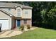 Charming two-story home features a blue front door, partial brick facade, and a well-manicured lawn at 3753 Soapstone Rd, Decatur, GA 30034
