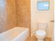 Bathroom featuring a white toilet, tiled shower, and a window letting in natural light at 4448 Tacoma Trce, Suwanee, GA 30024