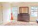 Bright bedroom featuring a dark wood dresser with a mirror and two windows letting in natural light at 4448 Tacoma Trce, Suwanee, GA 30024