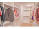 Walk-in closet featuring white built-in shelves and hanging rods for organized storage at 4448 Tacoma Trce, Suwanee, GA 30024