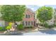 Two story brick home framed by two trees and manicured landscaping at 4448 Tacoma Trce, Suwanee, GA 30024